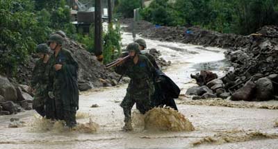 圖為救援官兵冒雨參與抗洪搶險。